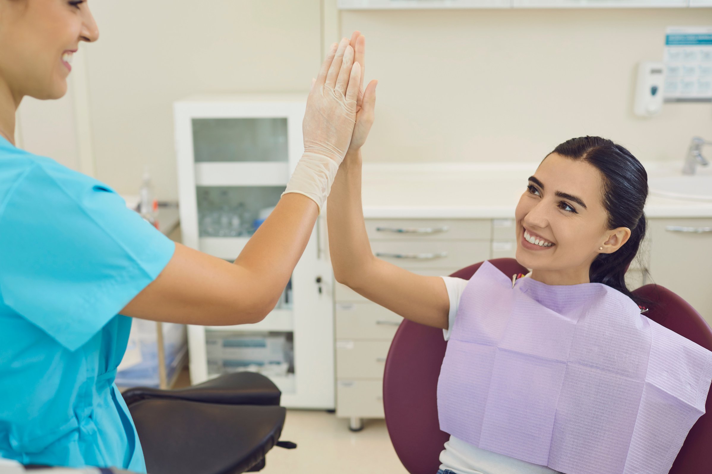 Happy Woman Is Happy with the Result of Dental Treatment and Gives Five to Her Dentist.